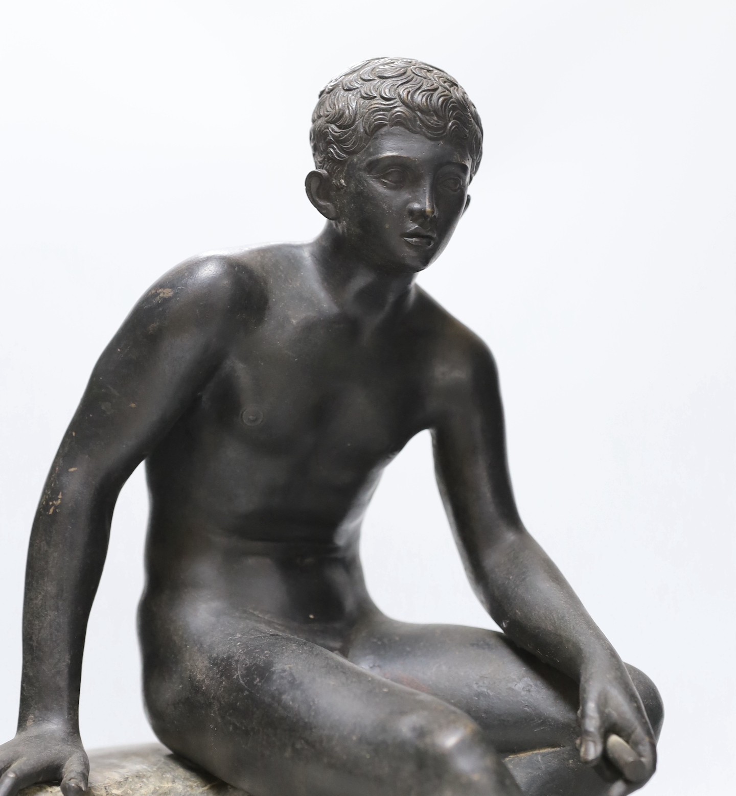 After the Antique, a late 19th century bronze figure of Mercury, seated on a grey marble naturalistic rocky base, 41cm high